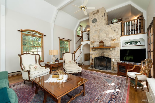 7975 00.25 Rd, Garden, MI 49835 - living room with wood finished floors, ceiling fan, a fireplace, high vaulted ceiling, and stairs