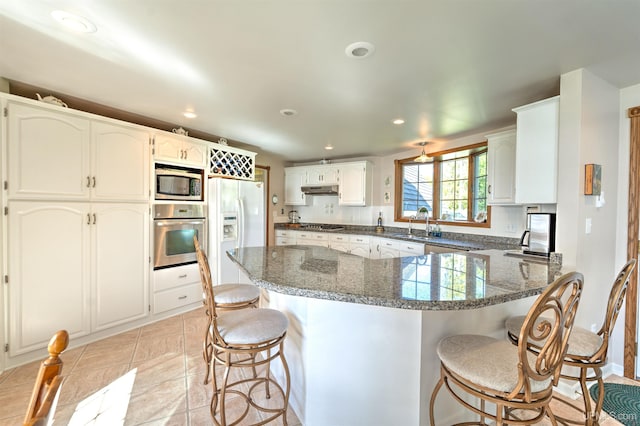 7975 00.25 Rd, Garden, MI 49835 - kitchen featuring appliances with stainless steel finishes, a peninsula, a kitchen bar, recessed lighting, and a sink