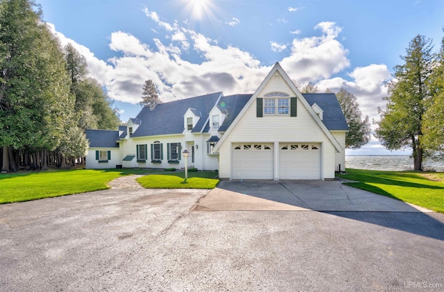 7975 00.25 Rd, Garden, MI 49835 - view of front facade featuring concrete driveway, a front yard, a water view, and a garage