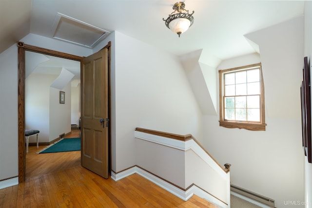 7975 00.25 Rd, Garden, MI 49835 - corridor featuring baseboard heating, an upstairs landing, vaulted ceiling, wood-type flooring, and attic access