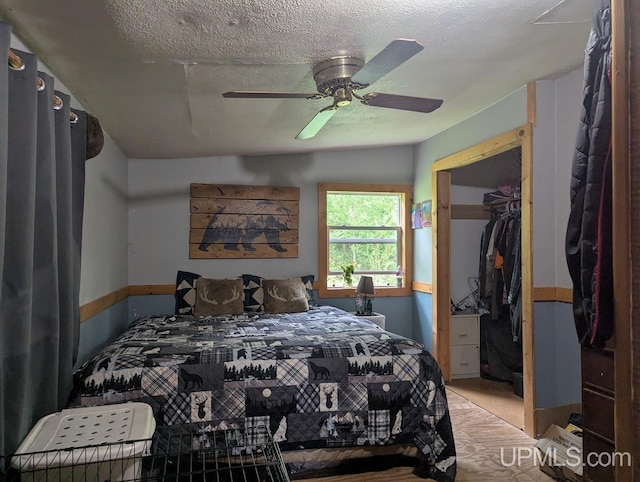 24662 Mud Creek Rd, Mass City, MI 49948 - carpeted bedroom featuring a textured ceiling, ceiling fan, a spacious closet, and a closet