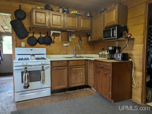 24662 Mud Creek Rd, Mass City, MI 49948 - kitchen featuring stainless steel microwave, white gas stove, a sink, brown cabinets, and light countertops