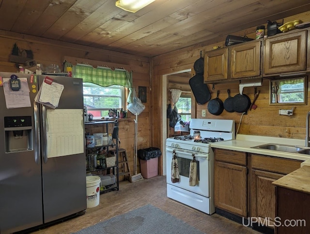 24662 Mud Creek Rd, Mass City, MI 49948 - kitchen with stainless steel fridge with ice dispenser, white gas range oven, wooden walls, a sink, and wood ceiling