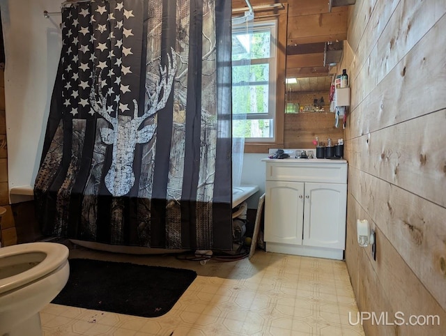 24662 Mud Creek Rd, Mass City, MI 49948 - full bath with wooden walls, vanity, tile patterned floors, and toilet