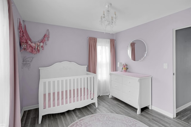 30 Connecticut St, Marysville, MI 48040 - bedroom with a chandelier, baseboards, wood finished floors, and a crib