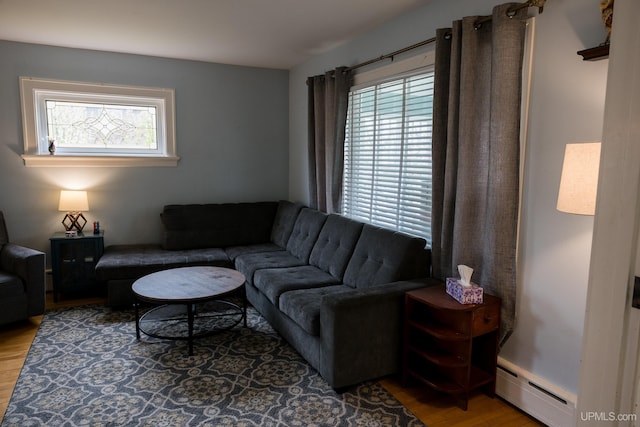 1302 N 3rd St, Ishpeming, MI 49849 - living room featuring wood finished floors, baseboard heating, and plenty of natural light