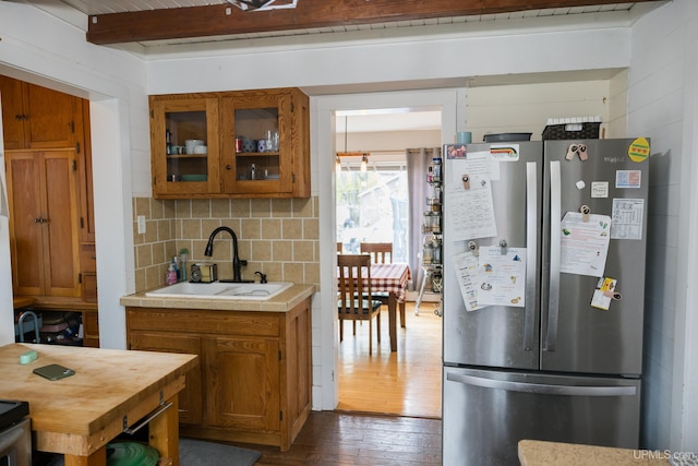 1302 N 3rd St, Ishpeming, MI 49849 - kitchen with freestanding refrigerator, a sink, dark wood finished floors, brown cabinetry, and beamed ceiling