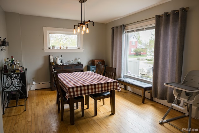 1302 N 3rd St, Ishpeming, MI 49849 - dining space with light wood-type flooring, plenty of natural light, a chandelier, and a baseboard heating unit