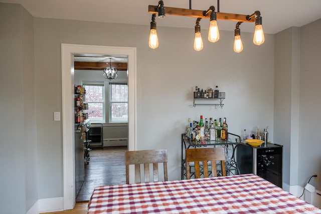 1302 N 3rd St, Ishpeming, MI 49849 - dining space with a baseboard heating unit, wood finished floors, a chandelier, and bar