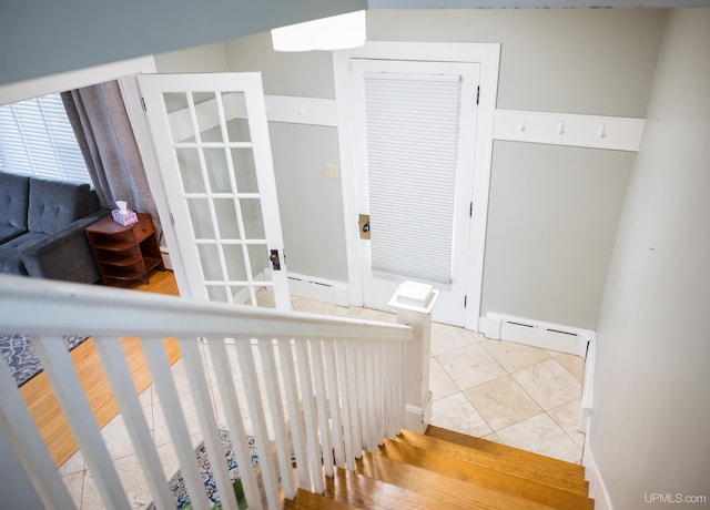1302 N 3rd St, Ishpeming, MI 49849 - staircase with baseboard heating, tile patterned flooring, baseboards, and a baseboard radiator