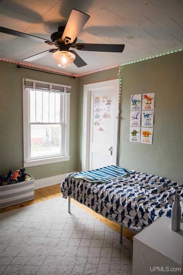 1302 N 3rd St, Ishpeming, MI 49849 - bedroom featuring wood finished floors, a ceiling fan, and baseboards