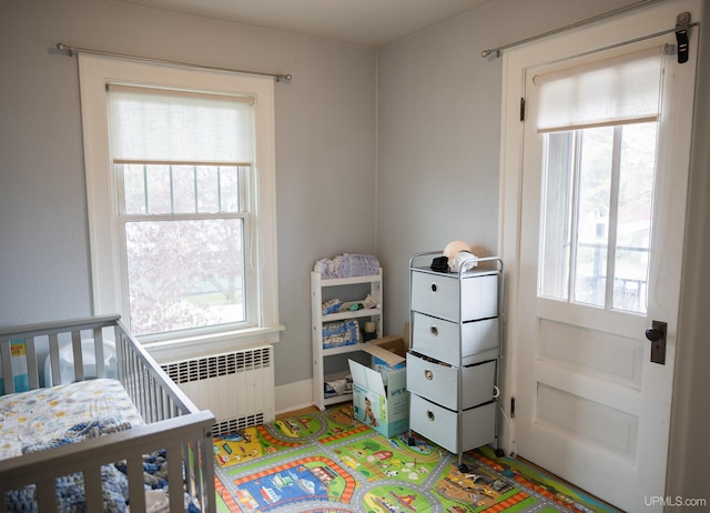 1302 N 3rd St, Ishpeming, MI 49849 - bedroom featuring radiator heating unit, multiple windows, and a nursery area