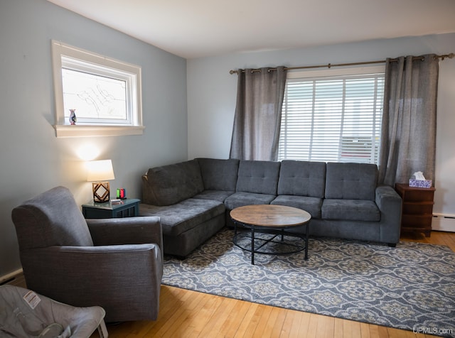 1302 N 3rd St, Ishpeming, MI 49849 - living area with healthy amount of natural light, hardwood / wood-style flooring, and a baseboard heating unit