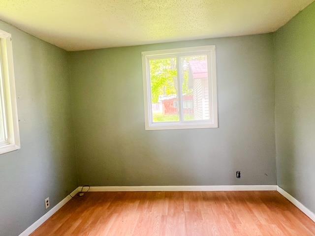 4815 Knollwood Dr, Harrison, MI 48625 - spare room with wood finished floors and baseboards