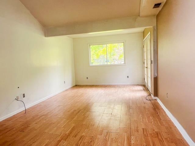 4815 Knollwood Dr, Harrison, MI 48625 - unfurnished room featuring light wood-style flooring, baseboards, and beamed ceiling