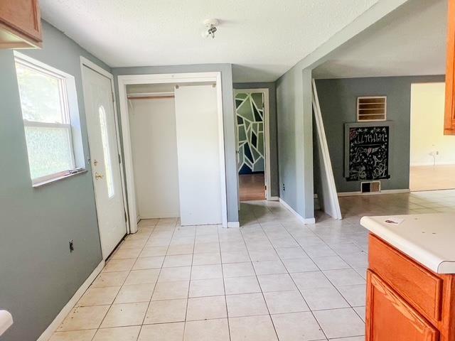 4815 Knollwood Dr, Harrison, MI 48625 - unfurnished dining area with light tile patterned floors and baseboards