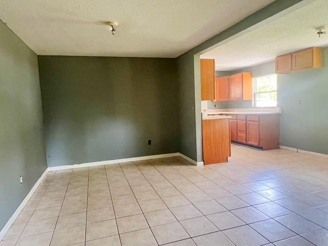 4815 Knollwood Dr, Harrison, MI 48625 - kitchen with a textured ceiling, light tile patterned floors, light countertops, and baseboards