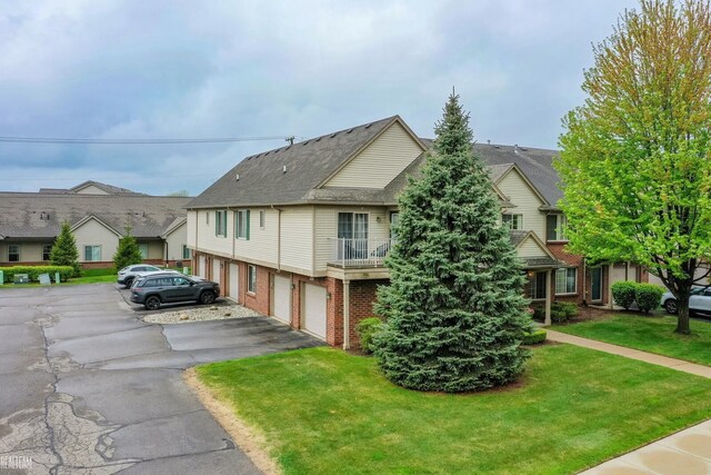 45537 Hidden View Ct, Utica, MI 48315 - view of front of home with asphalt driveway, brick siding, a garage, a front yard, and a balcony