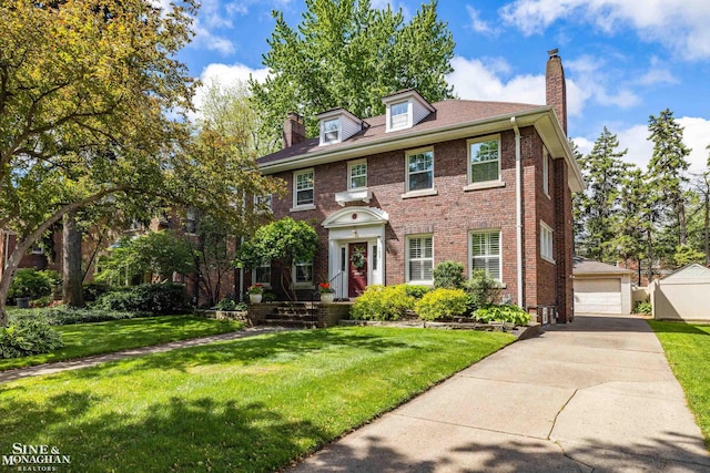 1435 Kensington Ave, Grosse Pointe Park, MI 48230 - colonial home featuring a chimney, an outdoor structure, brick siding, a front yard, and a detached garage