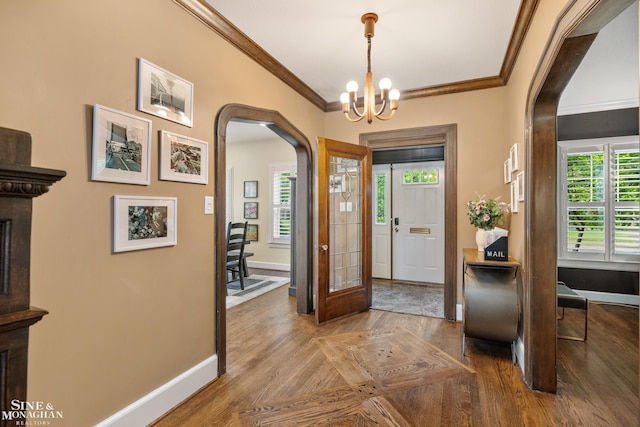 1435 Kensington Ave, Grosse Pointe Park, MI 48230 - foyer entrance featuring arched walkways, crown molding, baseboards, healthy amount of natural light, and a chandelier