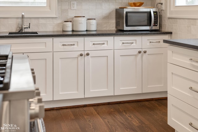 1435 Kensington Ave, Grosse Pointe Park, MI 48230 - kitchen featuring stainless steel microwave, a sink, white cabinetry, and backsplash