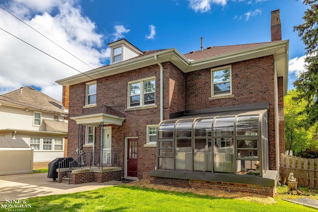 1435 Kensington Ave, Grosse Pointe Park, MI 48230 - rear view of property featuring a sunroom, brick siding, and a chimney