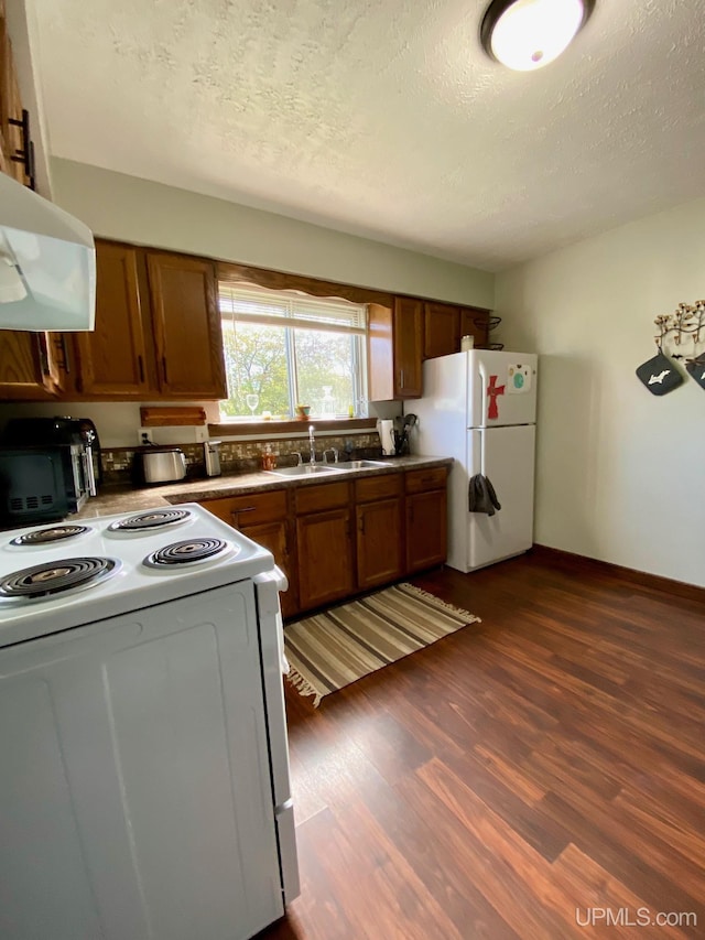 101-103 Juliet St, Marquette, MI 49855 - kitchen with white appliances, brown cabinetry, exhaust hood, a sink, and a textured ceiling