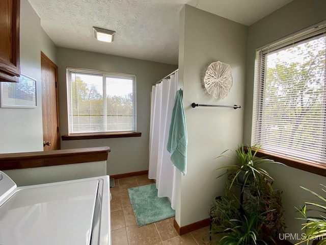 101-103 Juliet St, Marquette, MI 49855 - full bath with washer / clothes dryer, plenty of natural light, tile patterned flooring, and baseboards