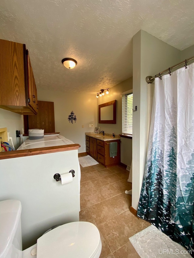 101-103 Juliet St, Marquette, MI 49855 - full bath with toilet, vanity, a textured ceiling, baseboards, and tile patterned flooring