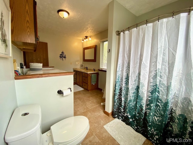 101-103 Juliet St, Marquette, MI 49855 - bathroom featuring toilet, vanity, tile patterned floors, curtained shower, and a textured ceiling