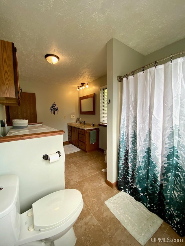 101-103 Juliet St, Marquette, MI 49855 - full bathroom with toilet, vanity, a textured ceiling, tile patterned flooring, and baseboards
