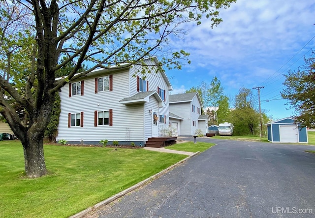 101-103 Juliet St, Marquette, MI 49855 - view of front facade with a garage, a front yard, an outbuilding, and asphalt driveway