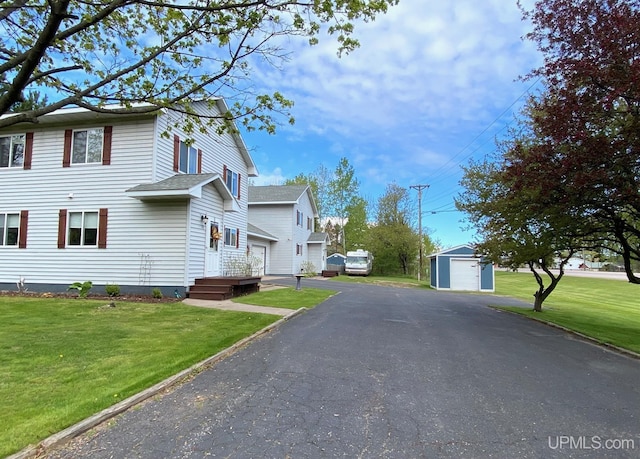 101-103 Juliet St, Marquette, MI 49855 - view of home's exterior featuring a garage, an outdoor structure, asphalt driveway, and a yard