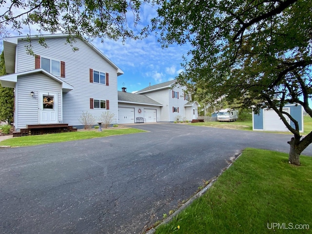 101-103 Juliet St, Marquette, MI 49855 - view of front facade with asphalt driveway, a garage, and a front lawn