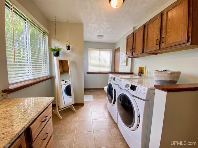 101-103 Juliet St, Marquette, MI 49855 - laundry room featuring cabinet space, separate washer and dryer, light tile patterned floors, a textured ceiling, and baseboards
