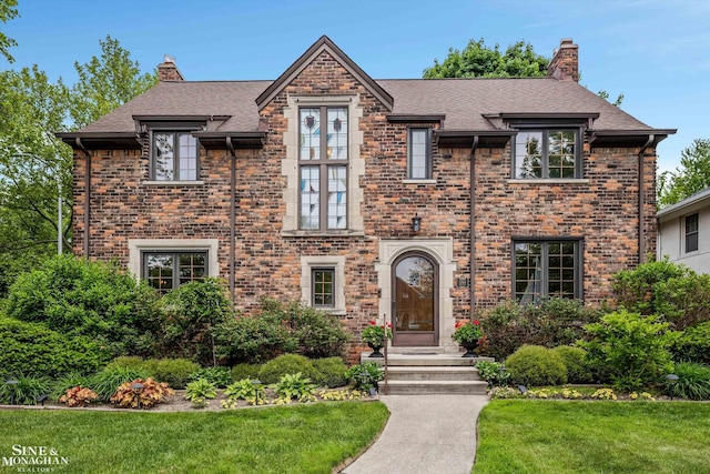 1264 Bedford Rd, Grosse Pointe Park, MI 48230 - view of front of house with a chimney, a front lawn, brick siding, and roof with shingles