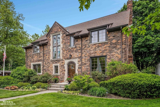 1264 Bedford Rd, Grosse Pointe Park, MI 48230 - tudor-style house with a front lawn, a chimney, brick siding, and a shingled roof