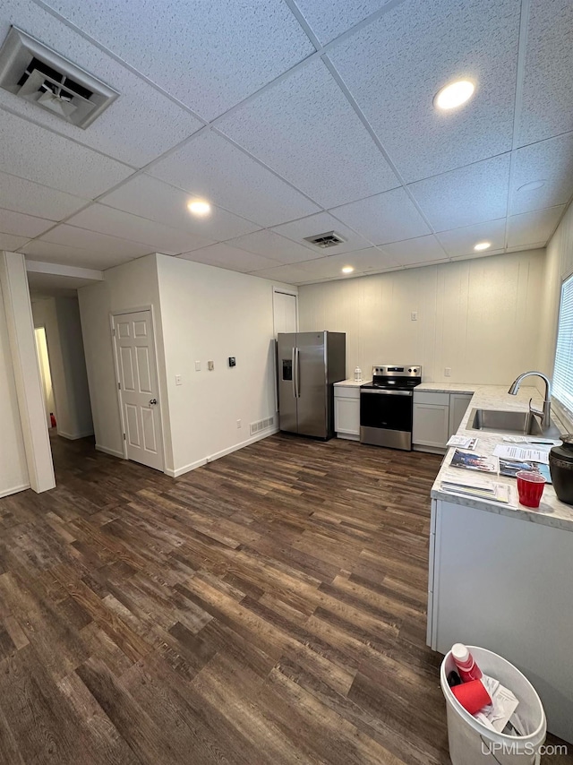 200 Marquette St, Negaunee, MI 49866 - kitchen with appliances with stainless steel finishes, dark wood-style floors, light countertops, a sink, and a paneled ceiling