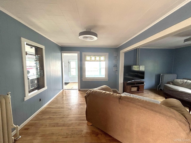 746 Maurice St, Ishpeming, MI 49849 - living room with crown molding, wood-type flooring, baseboards, and radiator heating unit