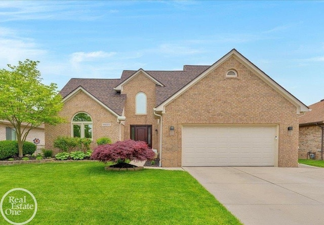 49204 Stratford Dr, Chesterfield Twp, MI 48047 - traditional home featuring driveway, a front lawn, brick siding, and a garage