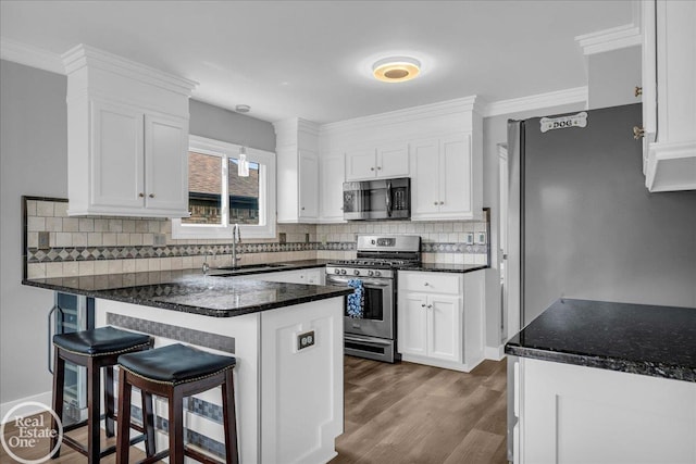 49204 Stratford Dr, Chesterfield Twp, MI 48047 - kitchen with stainless steel appliances, a sink, a peninsula, white cabinets, and crown molding