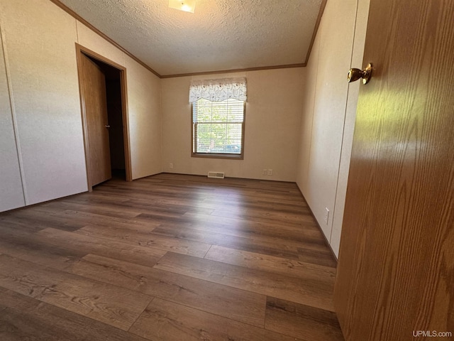 104 Pine St, Greenland, MI 49929 - unfurnished bedroom featuring wood finished floors, crown molding, and a textured ceiling