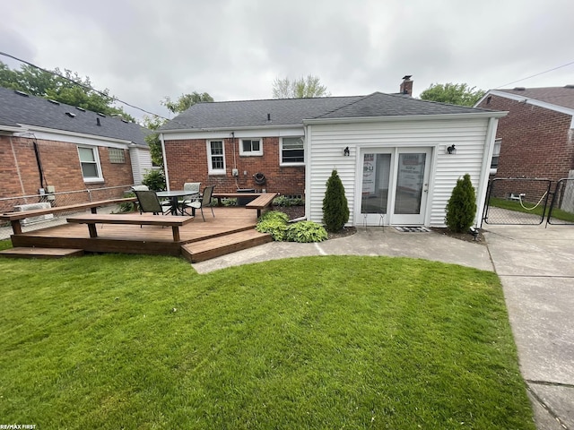 2029 Manchester Rd, Grosse Pointe Woods, MI 48236 - back of house featuring a wooden deck, a chimney, a gate, outdoor dining area, and brick siding