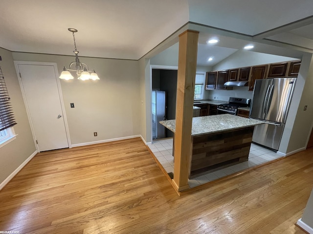 2029 Manchester Rd, Grosse Pointe Woods, MI 48236 - kitchen with appliances with stainless steel finishes, under cabinet range hood, light wood finished floors, dark brown cabinets, and a chandelier
