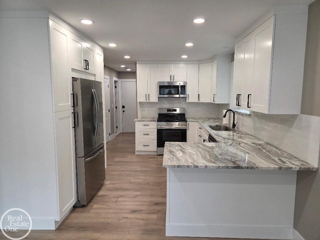 53340 Washington St, New Baltimore, MI 48047 - kitchen featuring appliances with stainless steel finishes, a sink, a peninsula, recessed lighting, and white cabinets