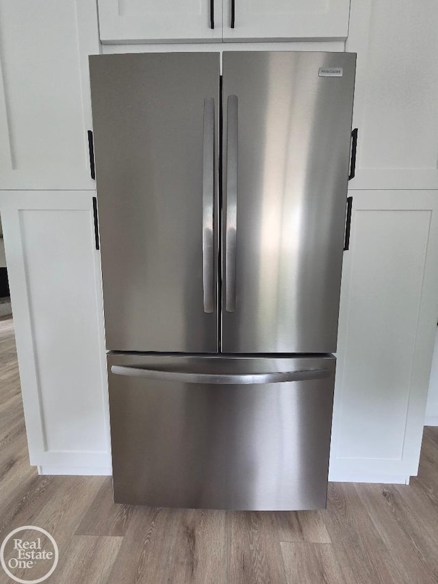 53340 Washington St, New Baltimore, MI 48047 - kitchen view of freestanding refrigerator, light wood-style flooring, and white cabinetry