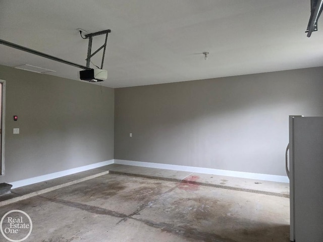 53340 Washington St, New Baltimore, MI 48047 - garage featuring freestanding refrigerator, a garage door opener, and baseboards