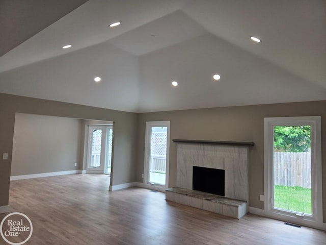 53340 Washington St, New Baltimore, MI 48047 - unfurnished living room with healthy amount of natural light, high vaulted ceiling, a fireplace, baseboards, and light wood-style flooring