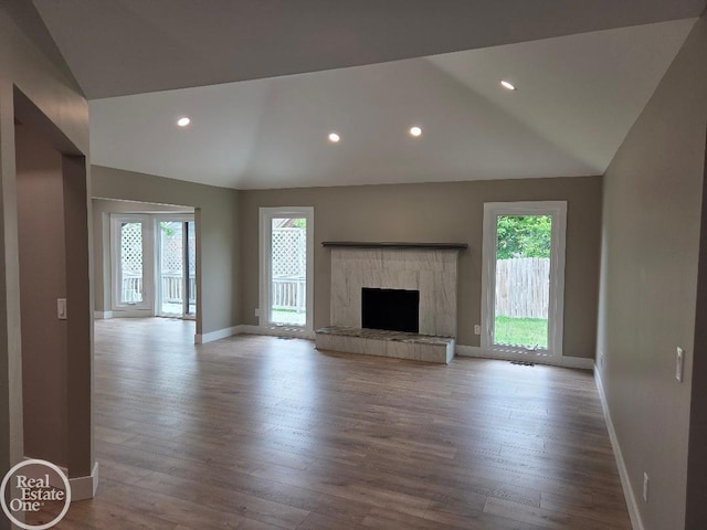 53340 Washington St, New Baltimore, MI 48047 - unfurnished living room with lofted ceiling, baseboards, wood finished floors, recessed lighting, and a tile fireplace