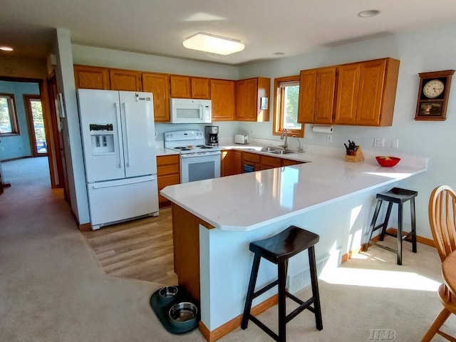 1750 Castleview Ct, Gladwin, MI 48624 - kitchen featuring white appliances, a sink, light colored carpet, brown cabinetry, and recessed lighting